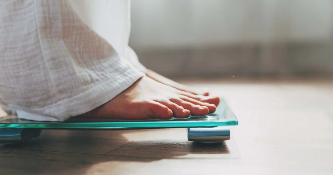 Person's feet standing on a scale Person's feet standing on a scale