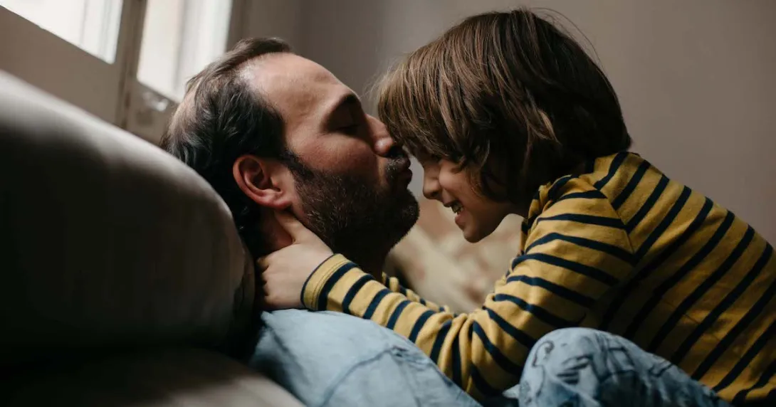 Father and son on a couch playing Father and son on a couch playing