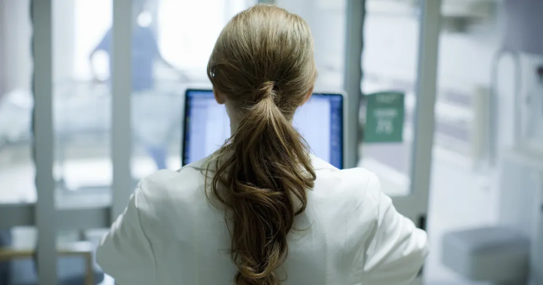 Healthcare provider with their back turned while looking at a computer
Healthcare provider with their back turned while looking at a computer