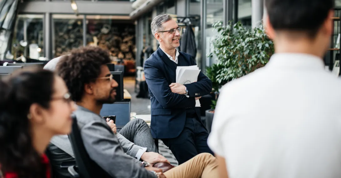 Employees sitting around and looking at something Employees sitting around and looking at something