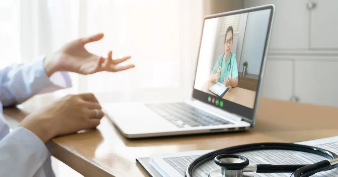Healthcare provider on a computer talking to someone Healthcare provider on a computer talking to someone