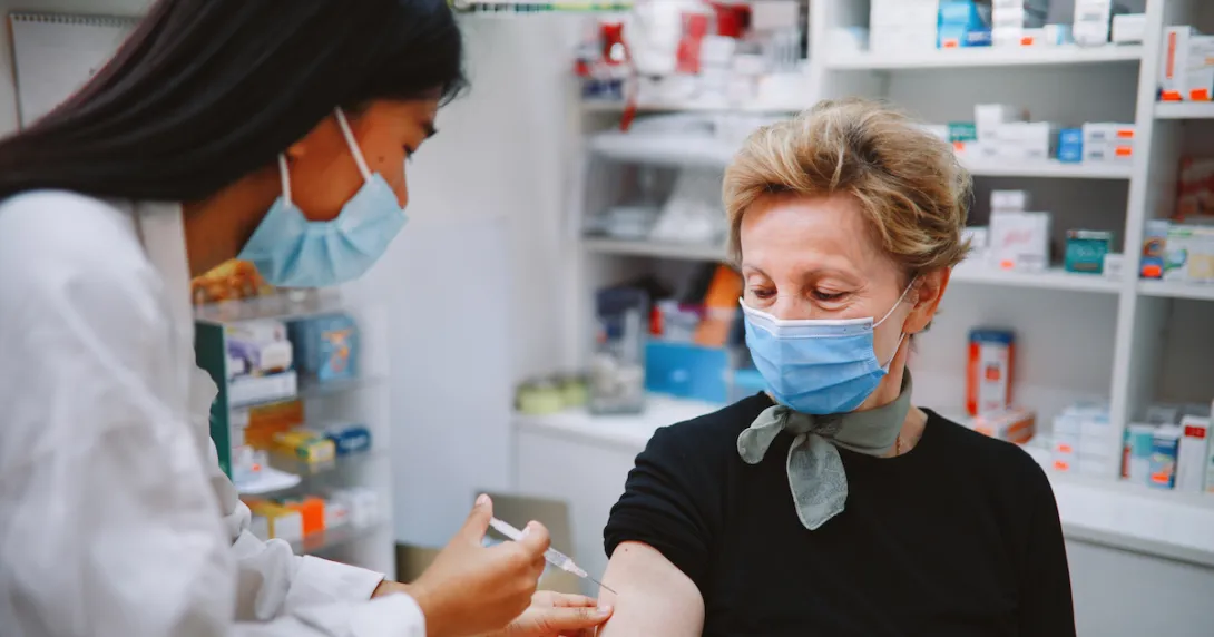 Pharmacist giving a person an injection Pharmacist giving a person an injection