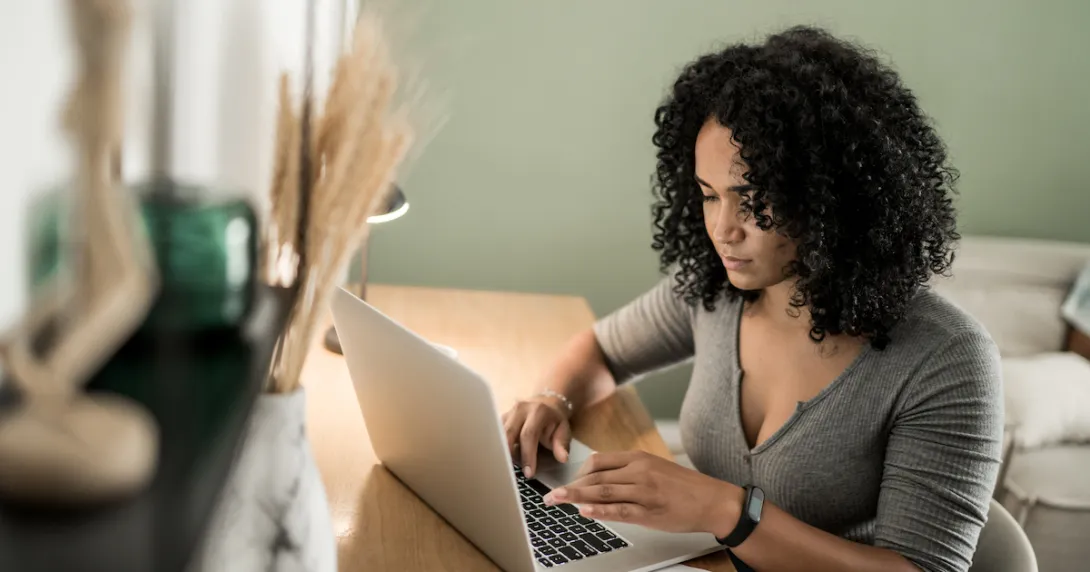 Person sitting at a desk while looking at a computer Person sitting at a desk while looking at a computer
