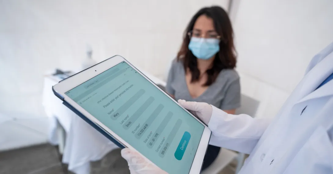Healthcare provider on a tablet with a patient sitting in a room
Healthcare provider on a tablet with a patient sitting in a room