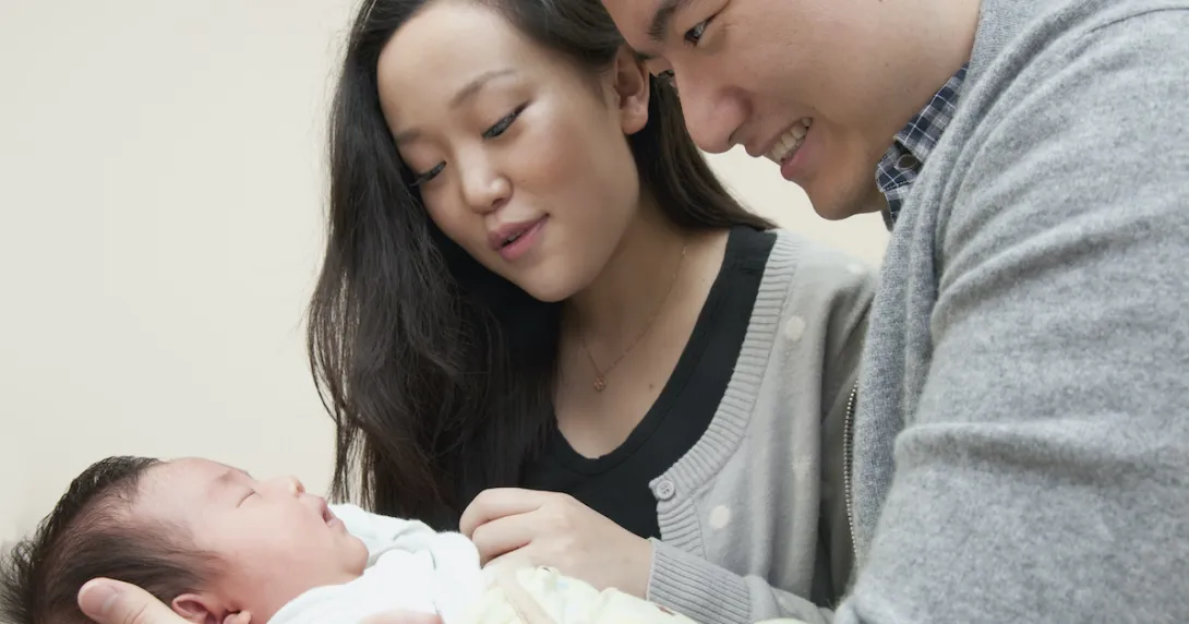 Parents holding their newborn child Parents holding their newborn child