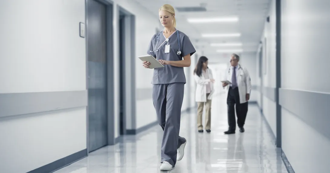 A nurse reading a medical chart through a digital tablet