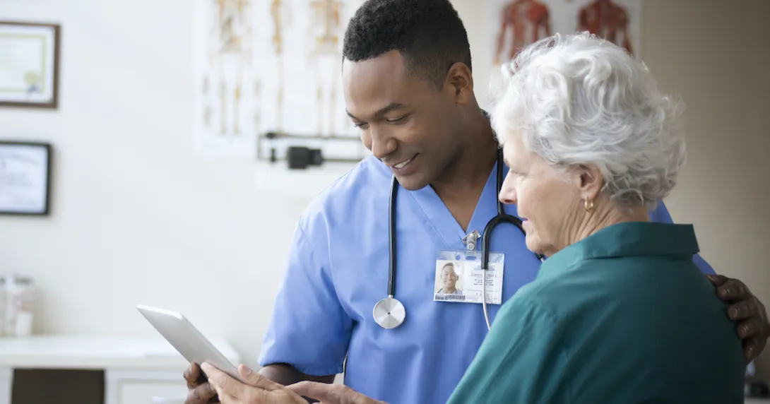 A nurse helping a senior patient use a digital tablet A nurse helping a senior patient use a digital tablet