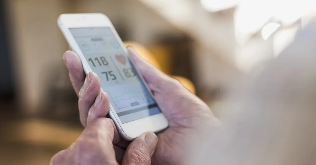 A person holding a phone showing a blood pressure reading A person holding a phone showing a blood pressure reading