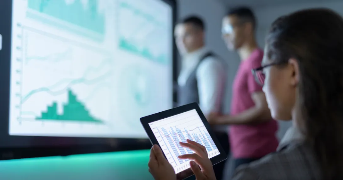 Three people in a room looking at different graphs on separate screens
Three people in a room looking at different graphs on separate screens
