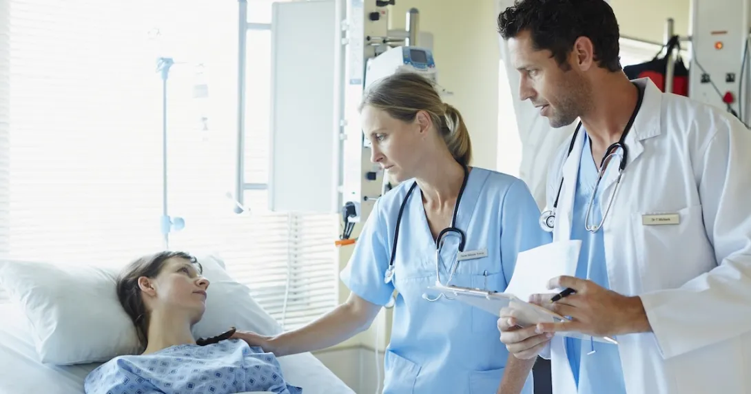 Healthcare professionals talking to a patient in a hospital Healthcare professionals talking to a patient in a hospital