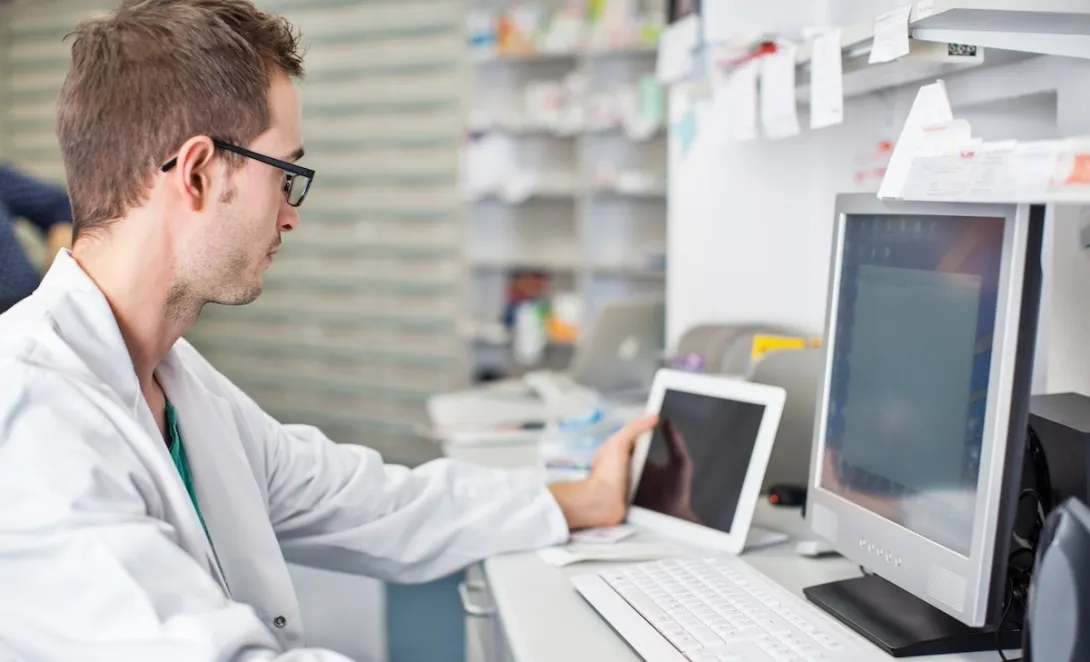 Clinician looking at data on a smart pad tablet and computer screen Clinician looking at data on a smart pad tablet and computer screen