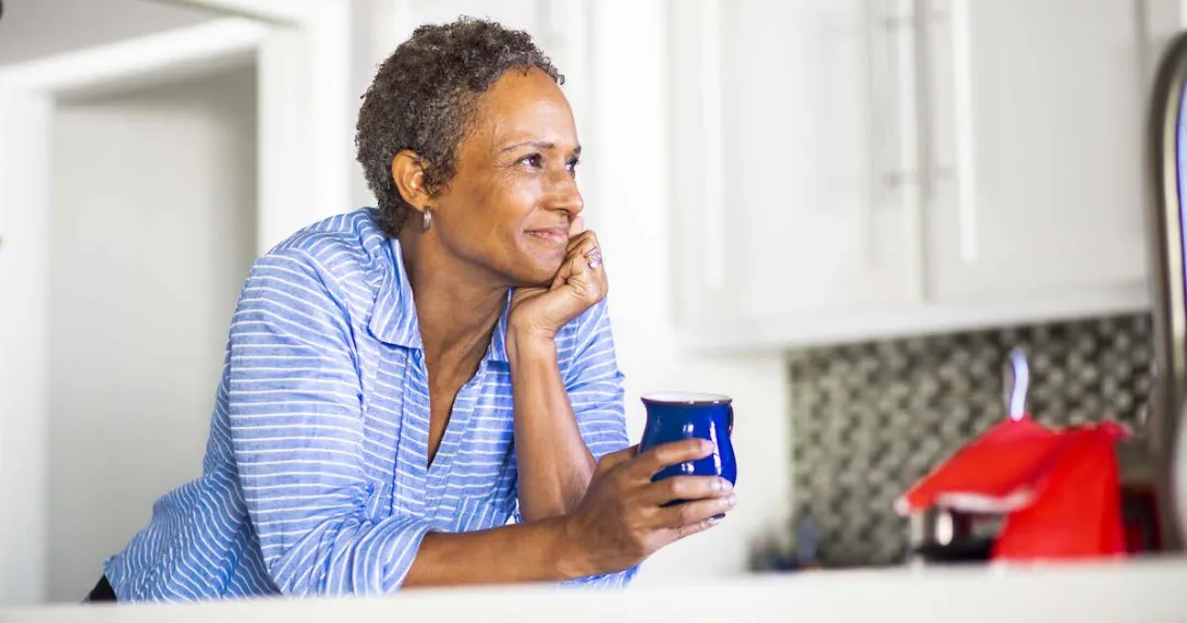Person leaning against a counter holding a coffee cup
Person leaning against a counter holding a coffee cup