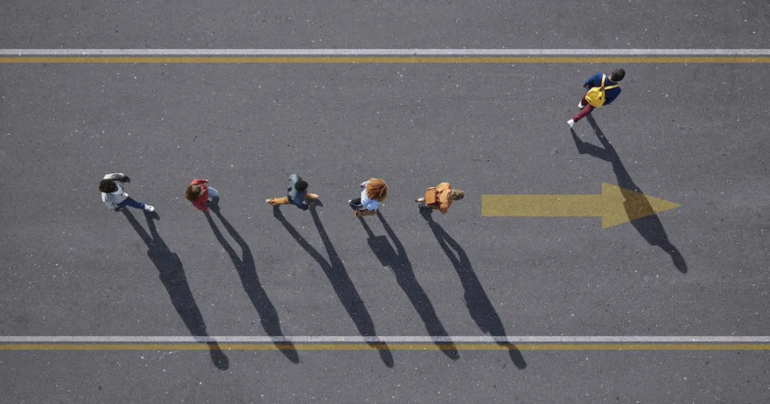People walking in a line with one person walking elsewhere People walking in a line with one person walking elsewhere
