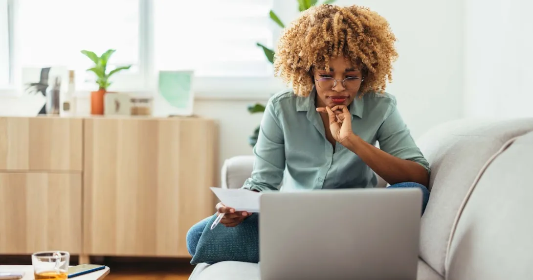 Individual sitting on a couch and looking at a computer Individual sitting on a couch and looking at a computer