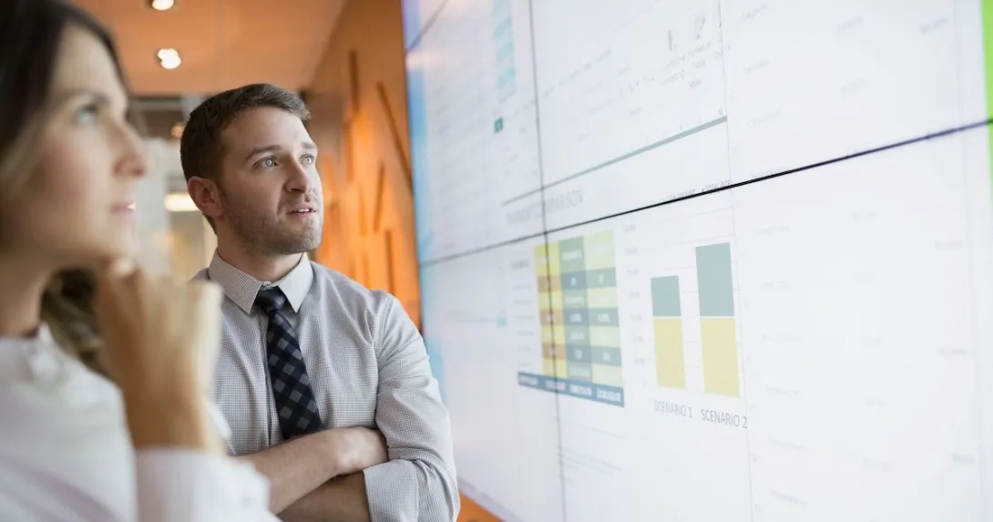 Businesspeople looking at financial results on a screen.
Businesspeople looking at financial results on a screen.