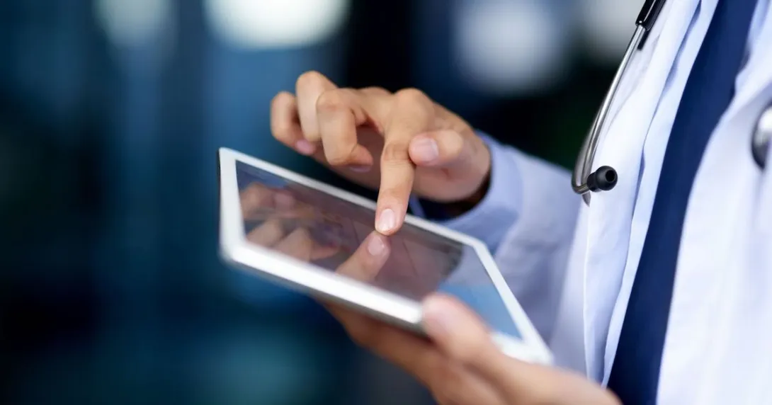 A close-up of a doctor using a tablet.
A close-up of a doctor using a tablet.