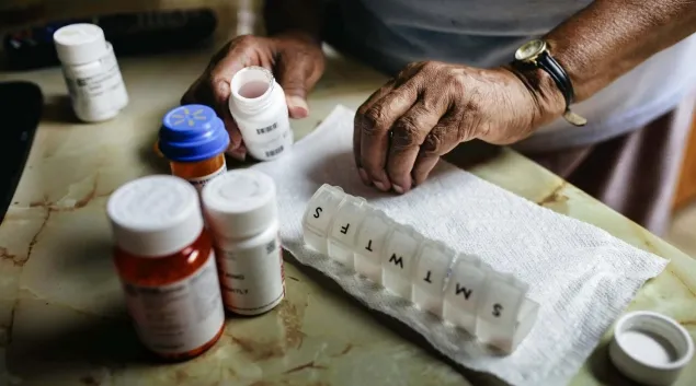 
  Hands and a pill organizer
