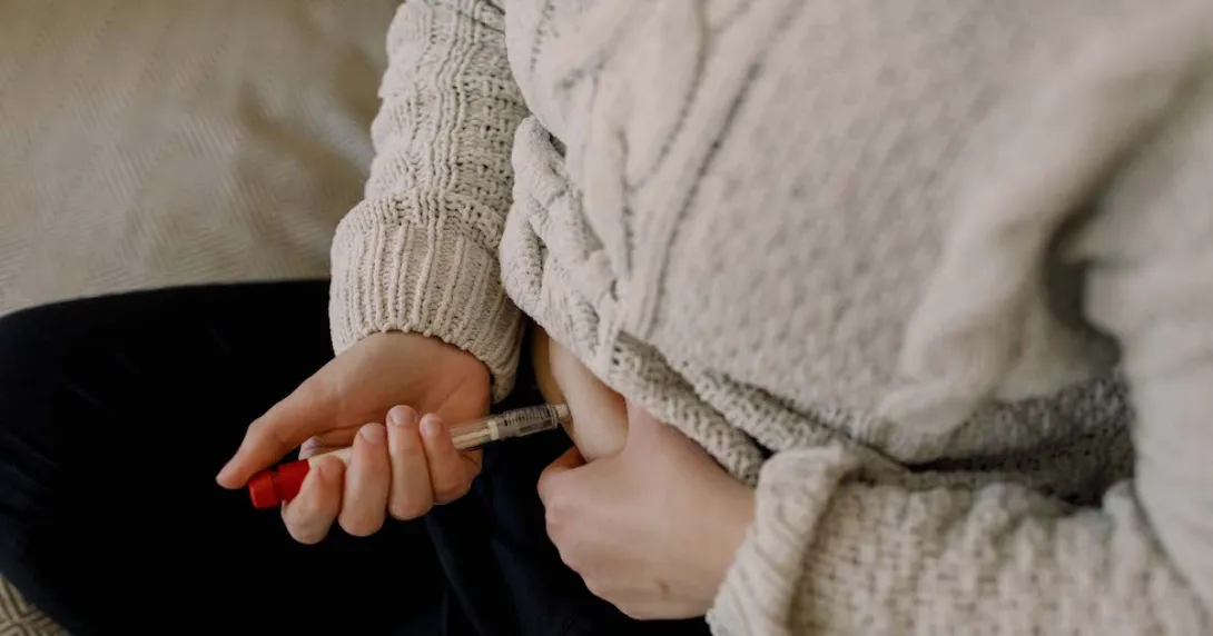 A close up of a person injecting fertility medication into their abdomen
A close up of a person injecting fertility medication into their abdomen