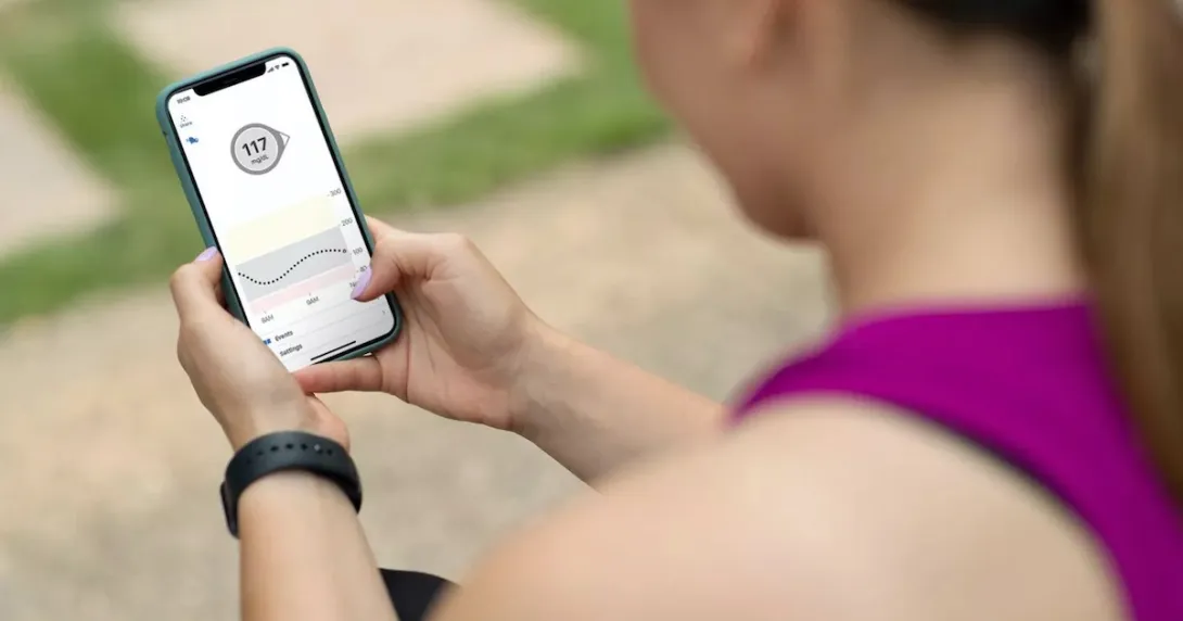 A Dexcom user checking their blood glucose level in real-time via mobile app
