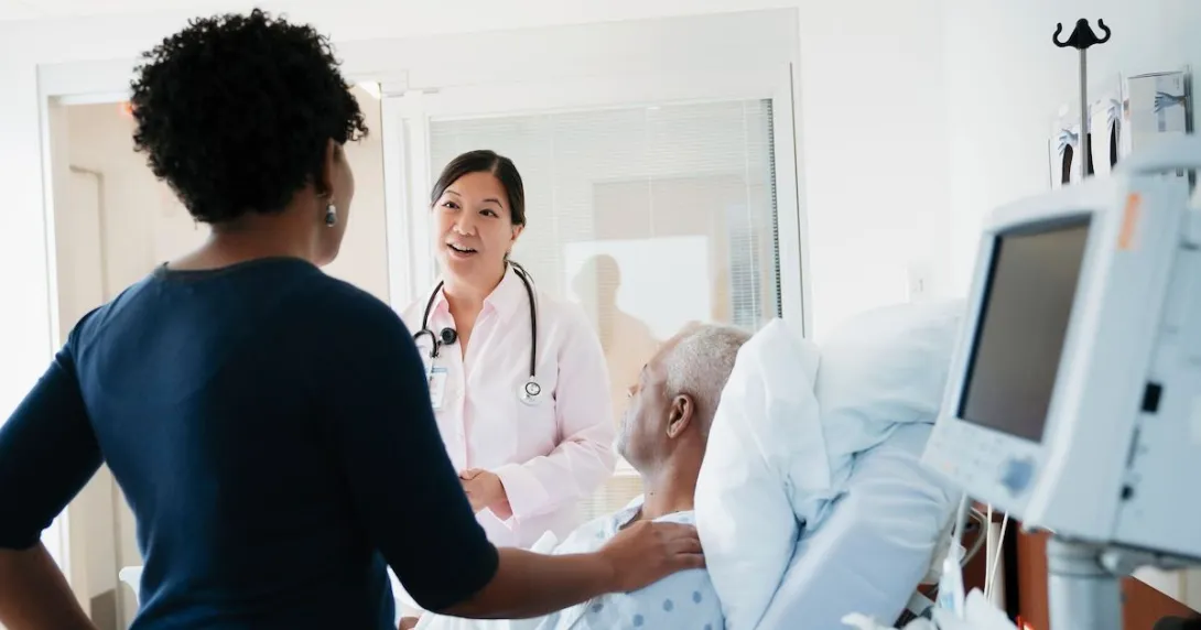 A doctor talking to patient and his family in a hospital room.
A doctor talking to patient and his family in a hospital room.