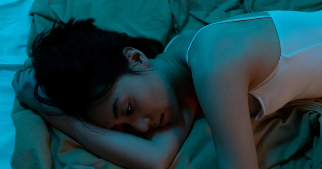 A seemingly depressed person lying in bed A seemingly depressed person lying in bed
