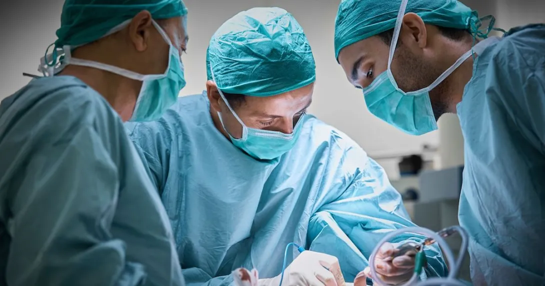Surgeons in an operating room performing a procedure Surgeons in an operating room performing a procedure