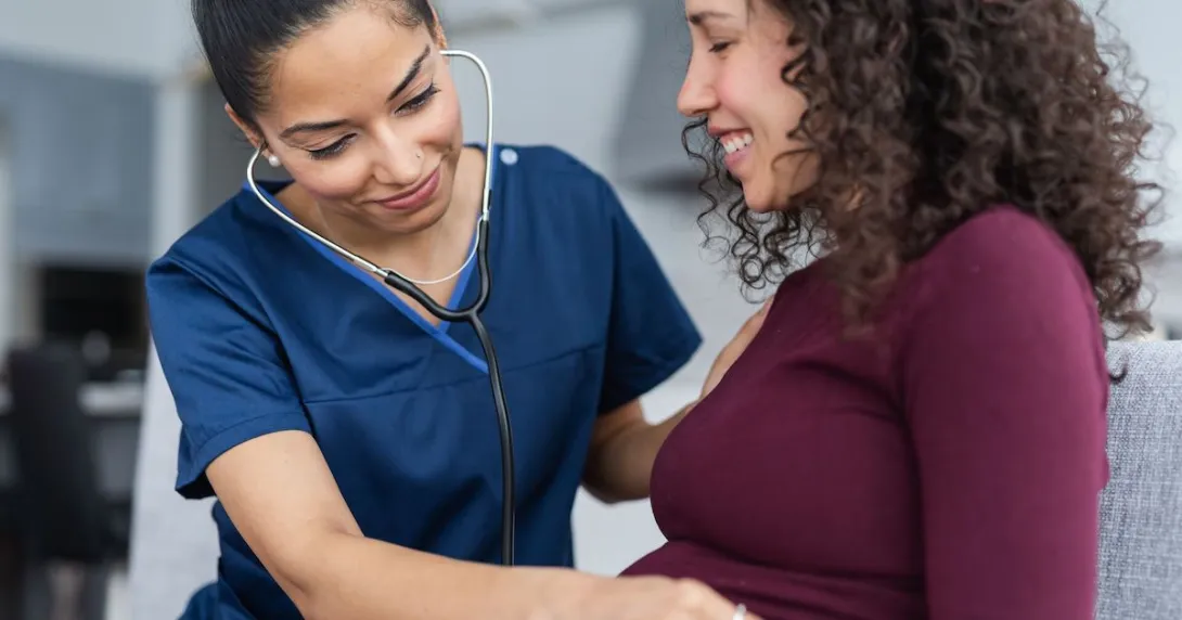Healthcare professional listening to a pregnant person's stomach with a stethoscope
Healthcare professional listening to a pregnant person's stomach with a stethoscope