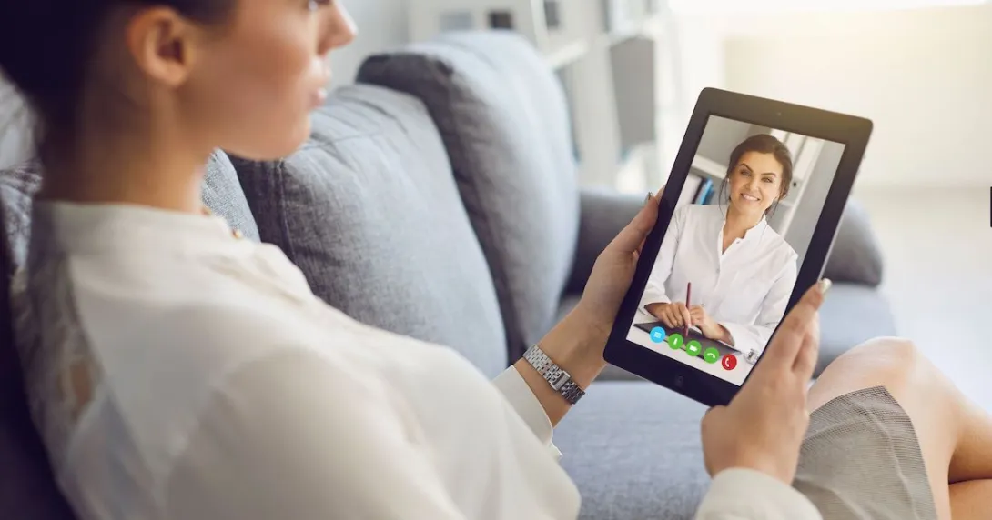 Person sitting on their couch speaking to a healthcare professional on a tablet
Person sitting on their couch speaking to a healthcare professional on a tablet