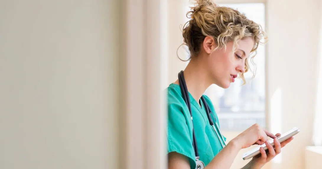 A nurse checking on their schedule in a digital tablet A nurse checking on their schedule in a digital tablet