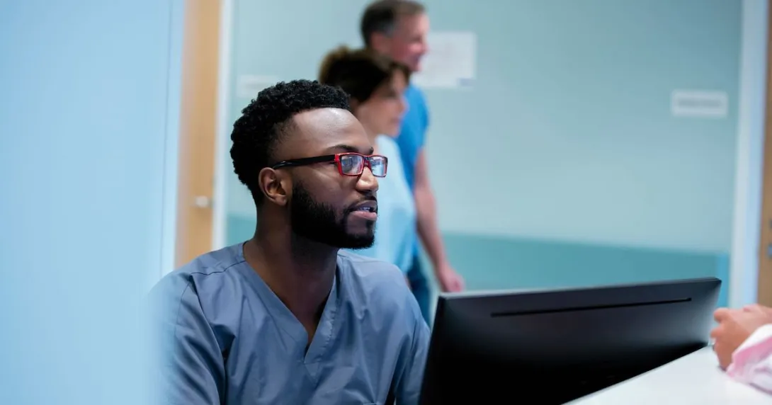 Healthcare provider in scrubs sitting at a computer
Healthcare provider in scrubs sitting at a computer