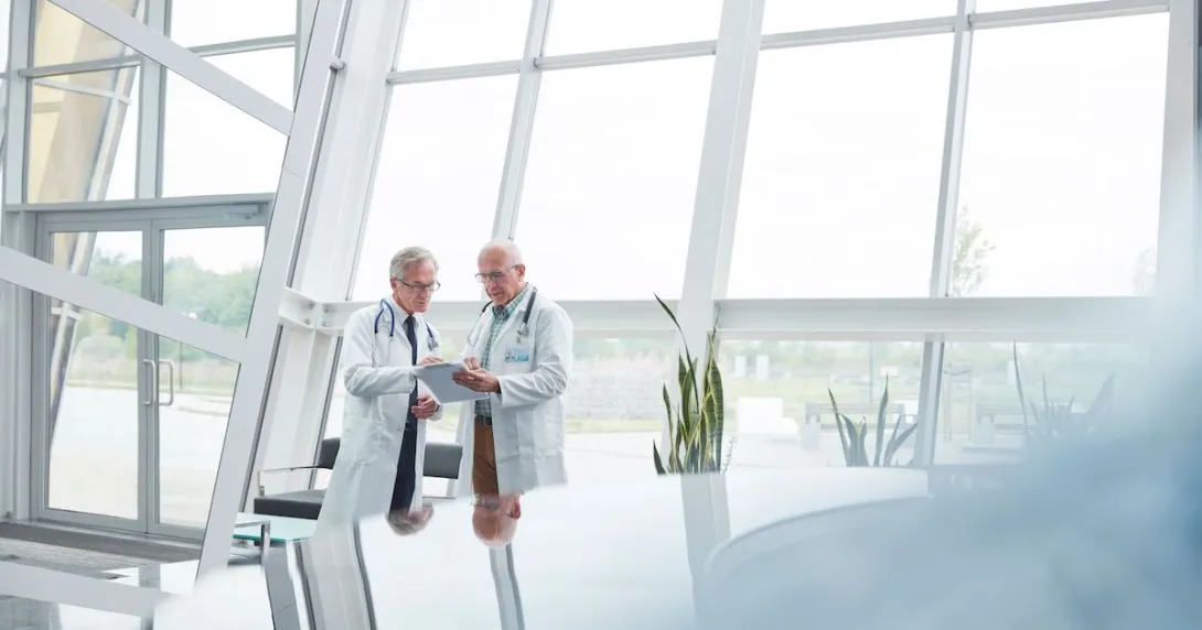 Two healthcare providers in a room with big windows
Two healthcare providers in a room with big windows