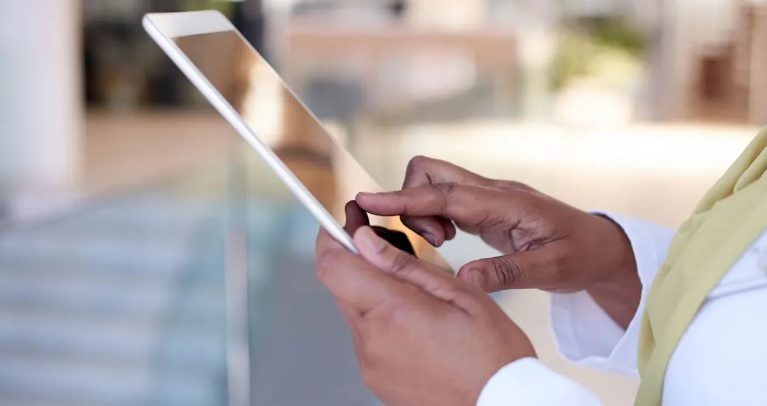 Person wearing a yellow scarf while holding a tablet Person wearing a yellow scarf while holding a tablet