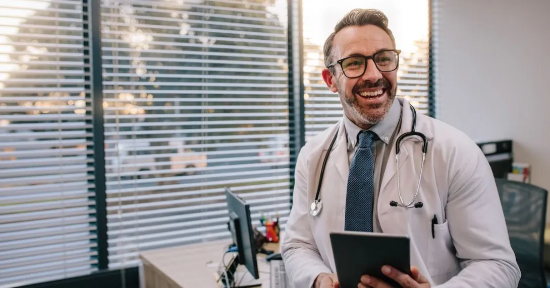 Doctor standing in a room and smiling Doctor standing in a room and smiling