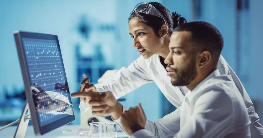 Two healthcare providers sitting in front of a computer touching the screen
Two healthcare providers sitting in front of a computer touching the screen
