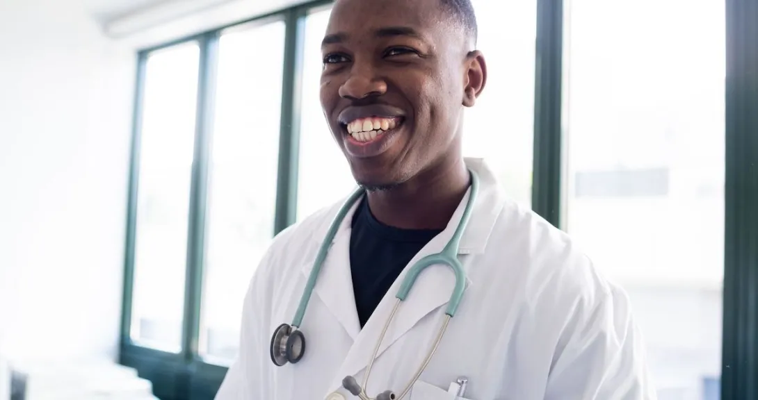Healthcare provider smiling while wearing a lab coat and stethoscope
Healthcare provider smiling while wearing a lab coat and stethoscope