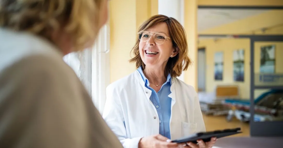 Healthcare provider speaking to a patient while smiling
Healthcare provider speaking to a patient while smiling