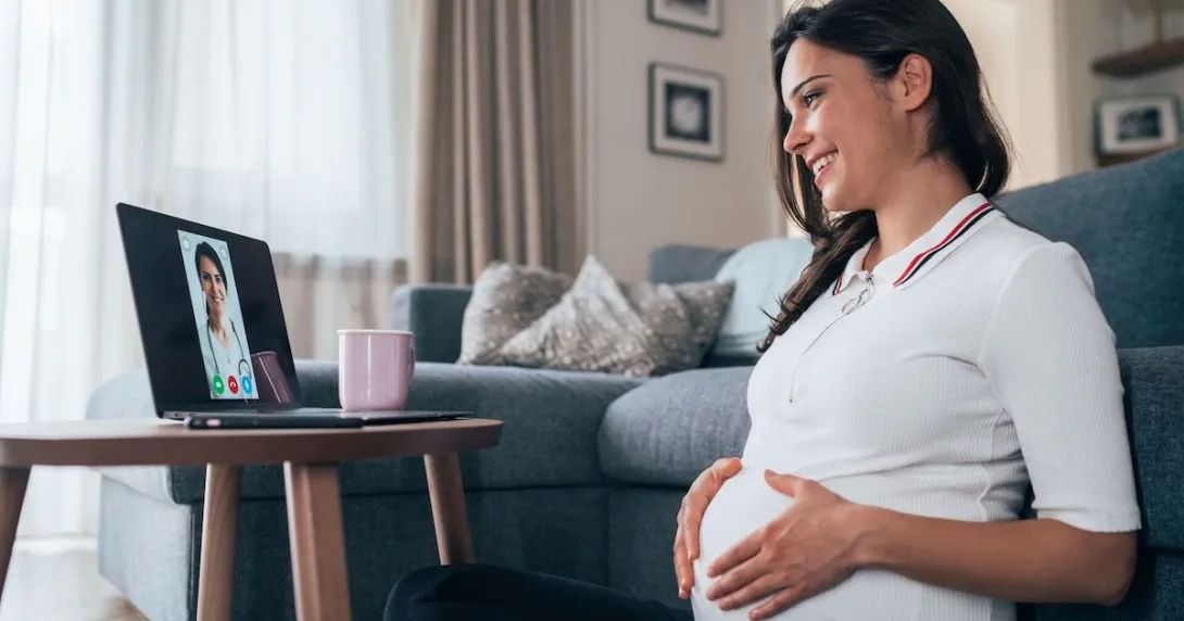 Pregnant person sitting on the floor looking at a computer
Pregnant person sitting on the floor looking at a computer