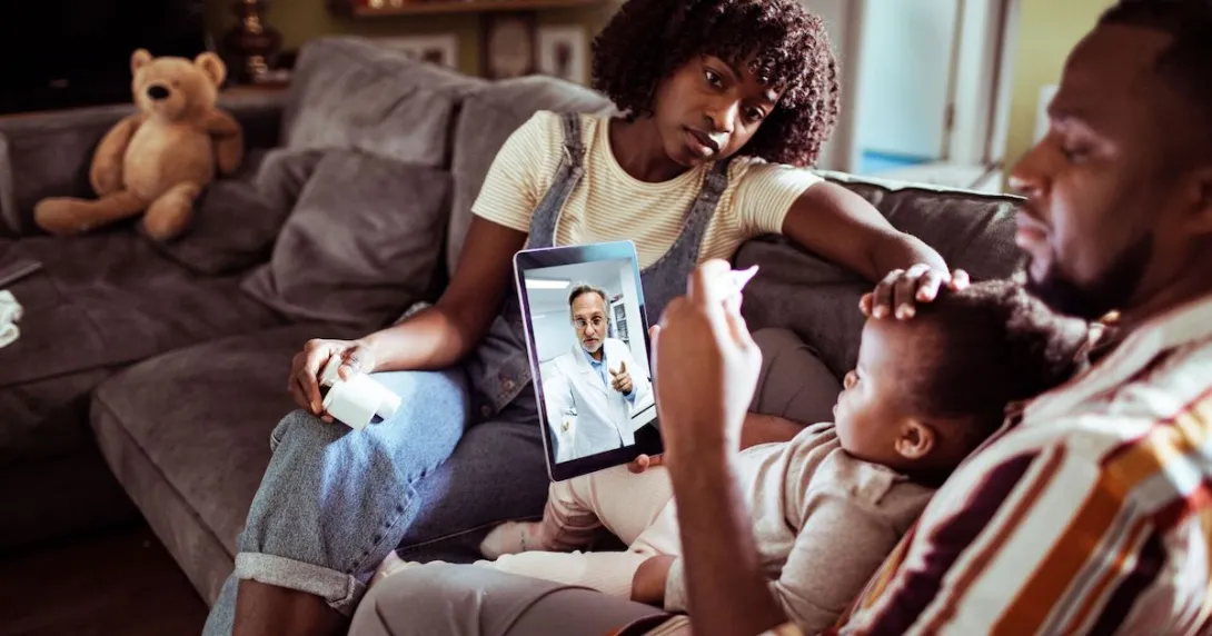 Two people sitting on a couch with a child sitting on one's lap while talking to a healthcare provider on a computer
Two people sitting on a couch with a child sitting on one's lap while talking to a healthcare provider on a computer