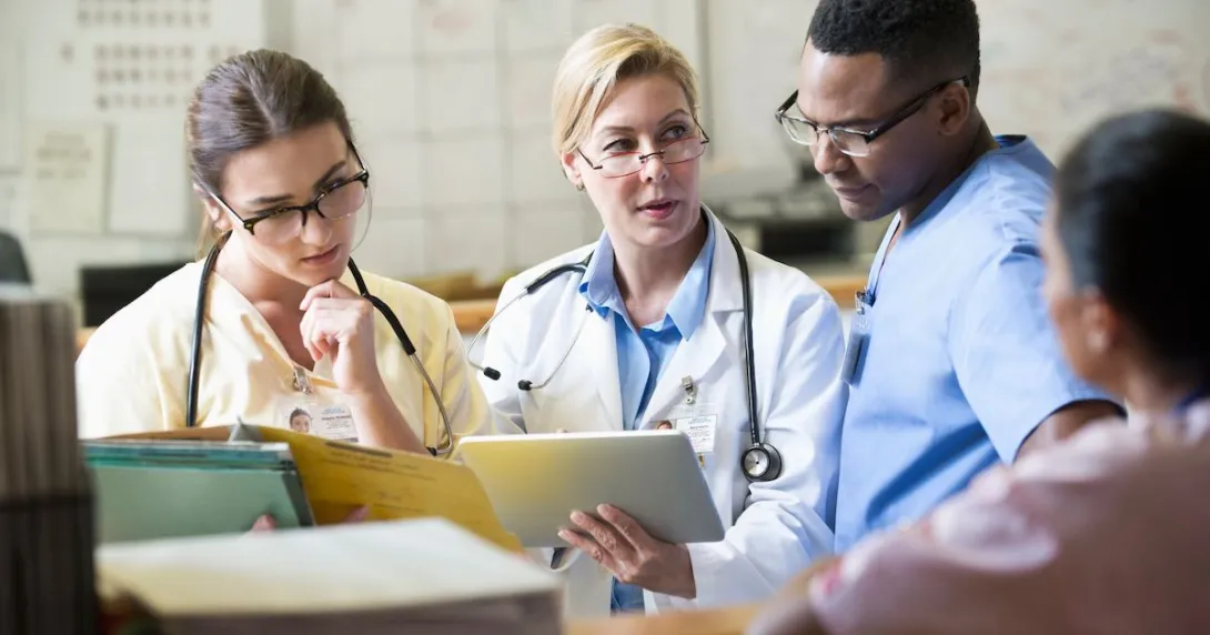 Three healthcare providers sitting together looking at a tablet together
Three healthcare providers sitting together looking at a tablet together