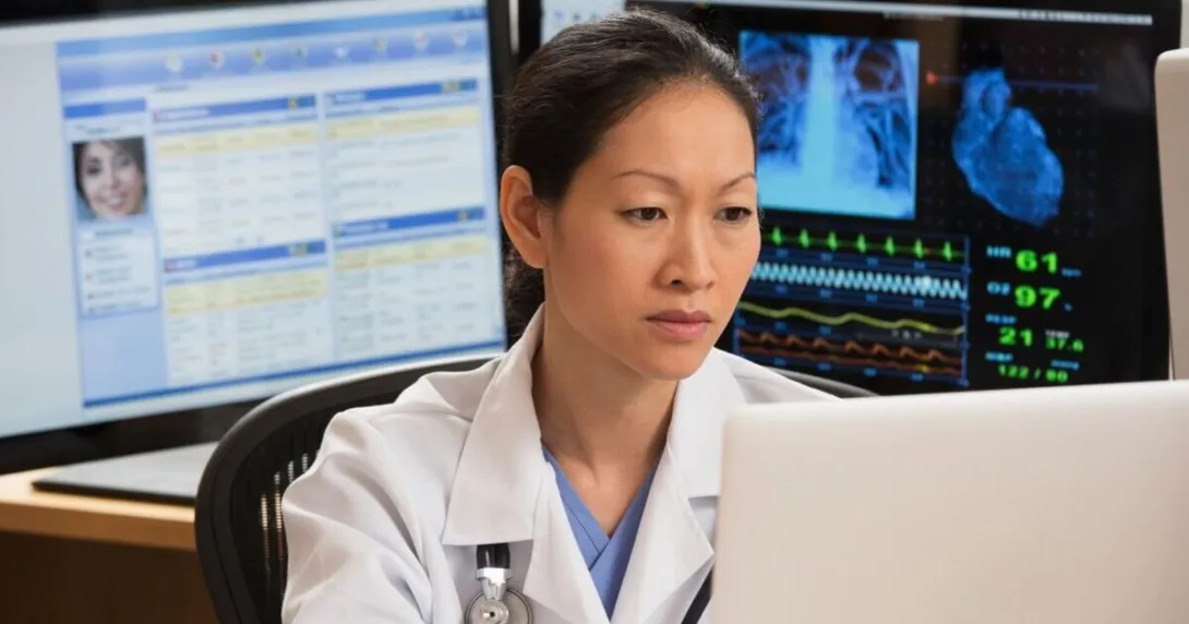 A doctor reviewing a patient's record on a laptop computer A doctor reviewing a patient's record on a laptop computer