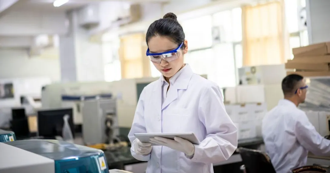 A lab researcher holding a digital tablet