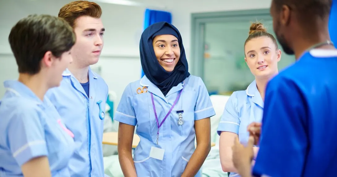Medical students chatting with their manager during a break after doing their rounds Medical students chatting with their manager during a break after doing their rounds