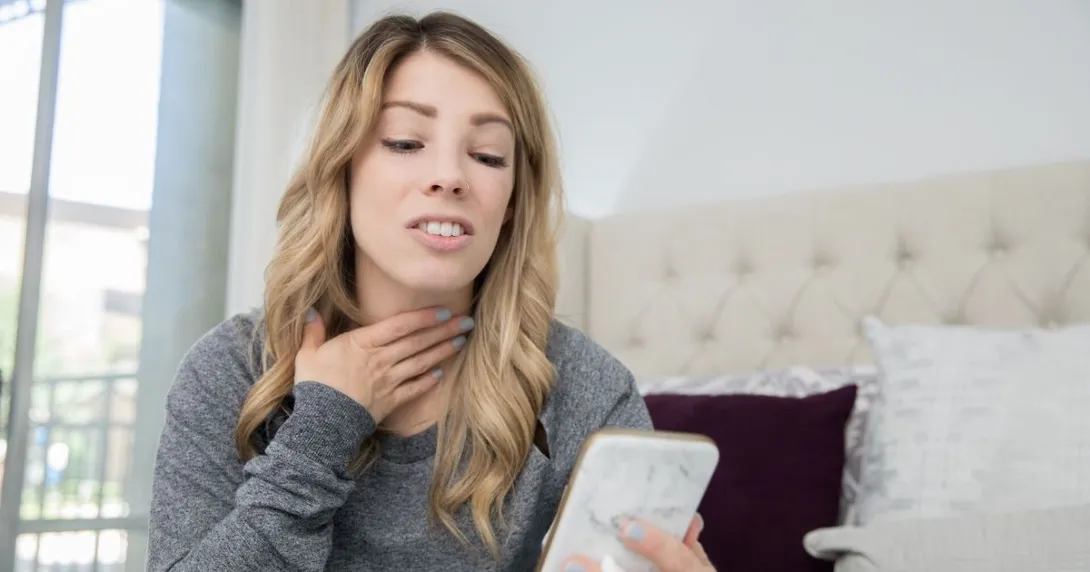 A person talking on a video chat on a phone about a sore throat
A person talking on a video chat on a phone about a sore throat