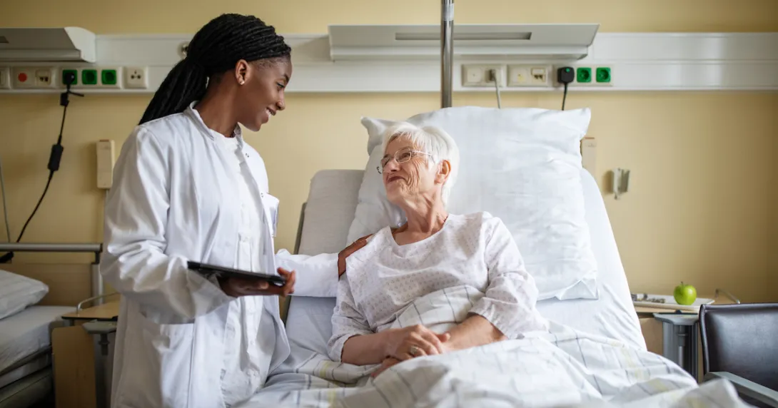 Healthcare provider talking to patient in a bed Healthcare provider talking to patient in a bed