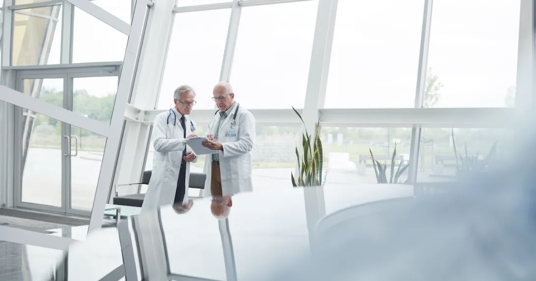 Two healthcare researchers speaking with each other Two healthcare researchers speaking with each other