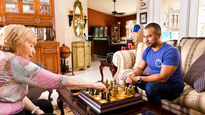 Papa Pal playing chess with woman