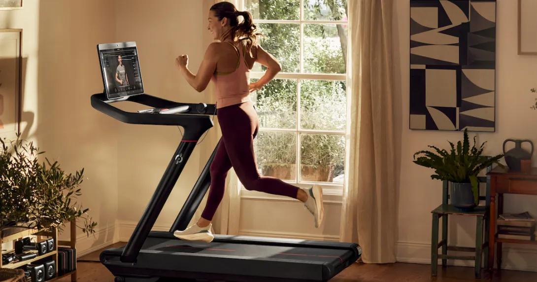 A woman running on a Peloton treadmill A woman running on a Peloton treadmill