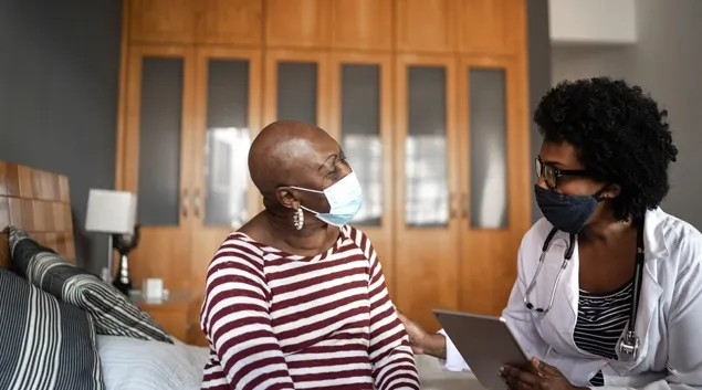 Doctor in mask talking to patient in mask