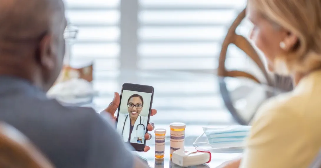 A couple talking to a doctor using a smartphone A couple talking to a doctor using a smartphone