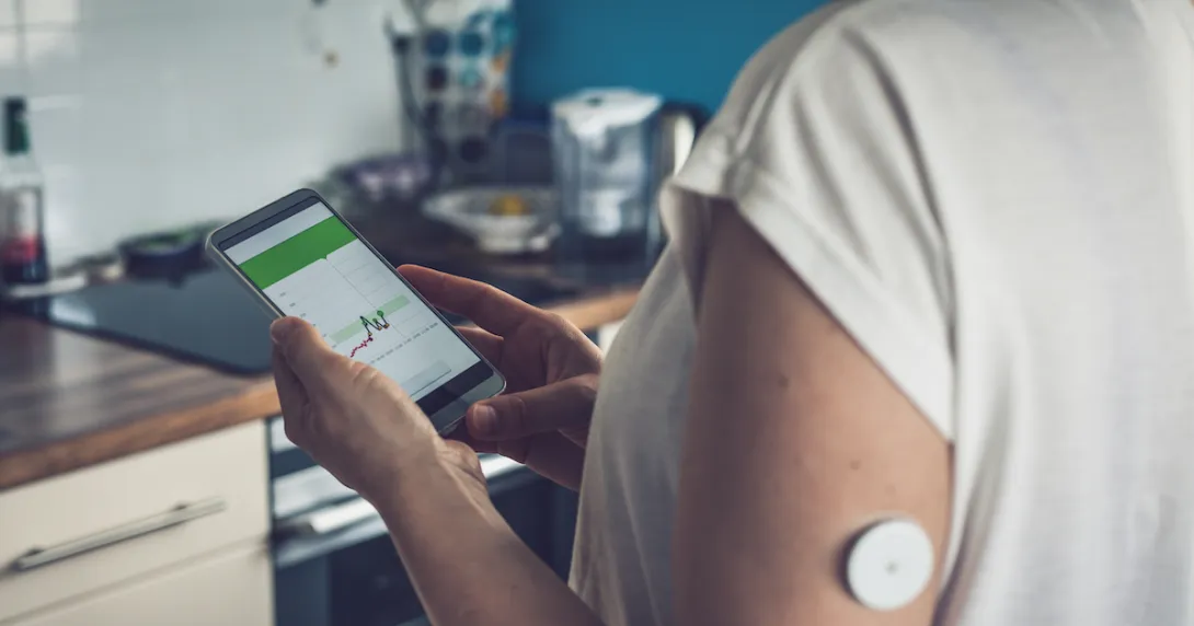 Woman checking glucose level with a remote sensor and mobile phone. Woman checking glucose level with a remote sensor and mobile phone.